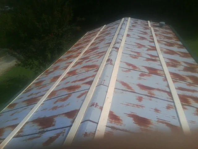 Rusted metal roof panels with new wood purlins before replacement — Storm Damage Roof Repair in Rex by Roofing Brothers